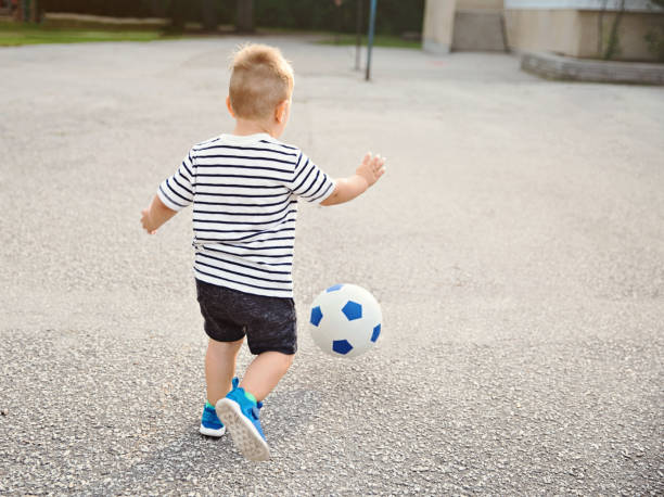 istock Young Boy Chasing a Soccer Ball 1216483285