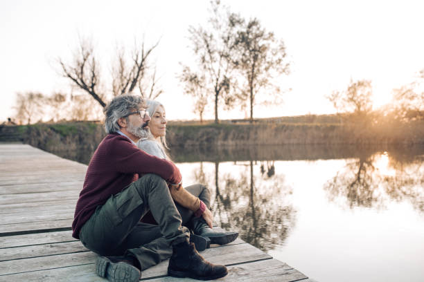 istock Senior couple enjoying the sunset view from the river dock 1216484050