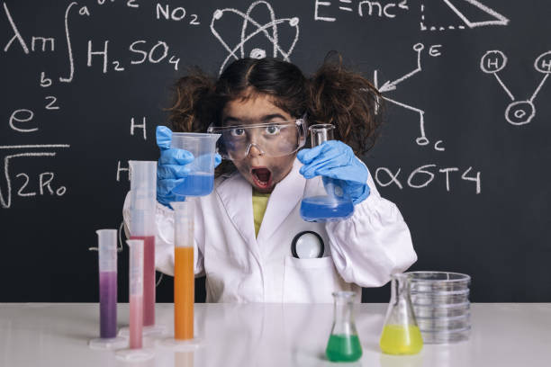 chica científica sorprendida con guantes en el abrigo de laboratorio - child discovery surprise playing fotografías e imágenes de stock