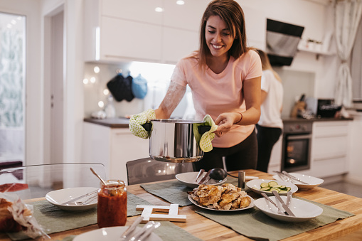 Two young women setting the table