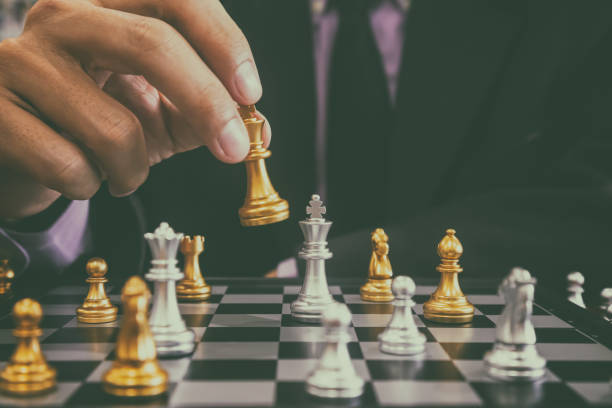 istock Chess game on chess board behind business man background. Business concept to present financial information and marketing strategy analysis. Investment target in global economy and digital commercial. 1216485546