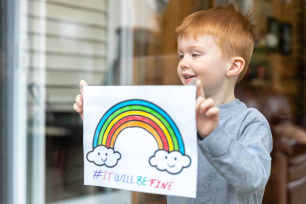 istock Young Boy sticking his drawing on home window during the Covid-19 crisis 1216489326