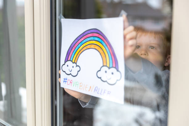 istock Young Boy sticking his drawing on home window during the Covid-19 crisis 1216489401