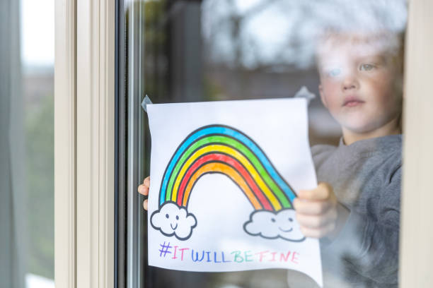 istock Young Boy sticking his drawing on home window during the Covid-19 crisis 1216489429