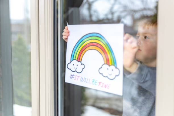 istock Young Boy sticking his drawing on home window during the Covid-19 crisis 1216489462
