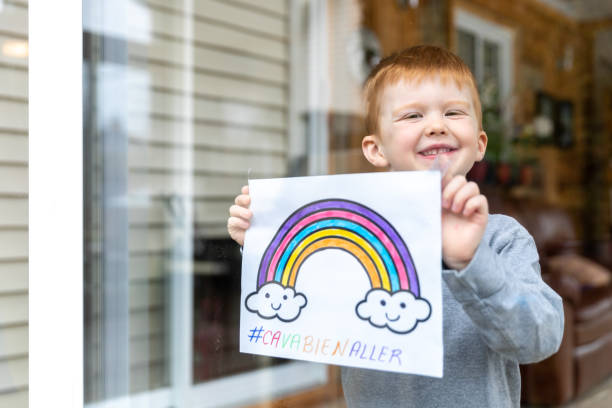 istock Young Boy sticking his drawing on home window during the Covid-19 crisis 1216489470