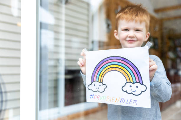 istock Young Boy sticking his drawing on home window during the Covid-19 crisis 1216489498
