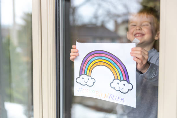 istock Young Boy sticking his drawing on home window during the Covid-19 crisis 1216489509