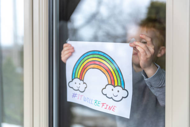 istock Young Boy sticking his drawing on home window during the Covid-19 crisis 1216489533