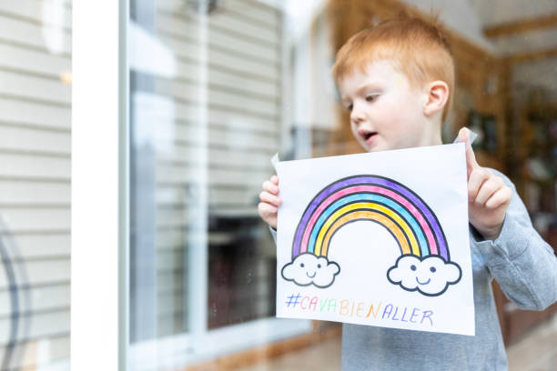 istock Young Boy sticking his drawing on home window during the Covid-19 crisis 1216489536