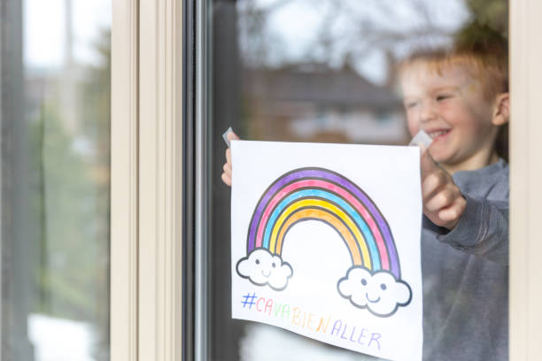 istock Young Boy sticking his drawing on home window during the Covid-19 crisis 1216489561