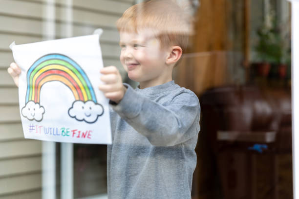 istock Young Boy sticking his drawing on home window during the Covid-19 crisis 1216489566