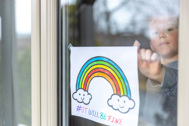istock Young Boy sticking his drawing on home window during the Covid-19 crisis 1216489577
