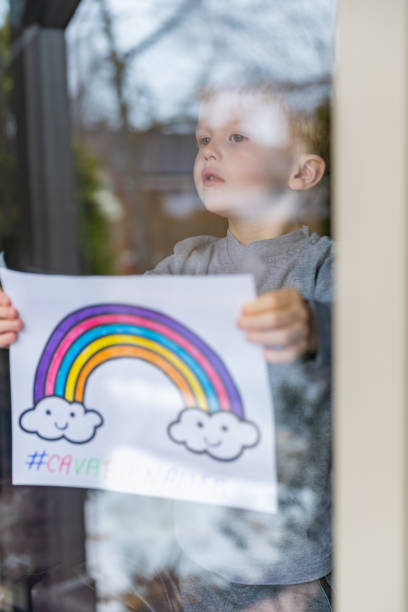 istock Young Boy sticking his drawing on home window during the Covid-19 crisis 1216489587