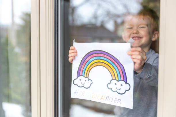 istock Young Boy sticking his drawing on home window during the Covid-19 crisis 1216489618