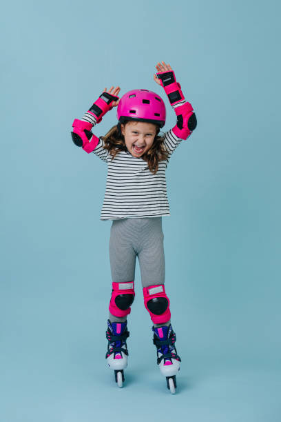 чрезмерно эмоциональный кричать маленькая девочка в роликовых коньках носить розовые защитные снасти - overemotional стоковые фото и изображения