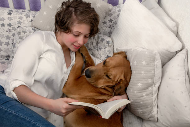 istock Teen reading with his dog 1216497818