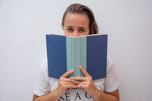 istock Woman looking above a book and smiling 1216499697