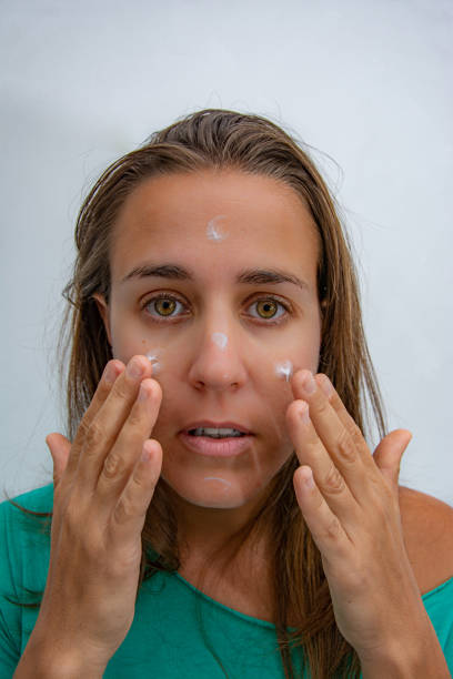 istock Woman putting cream on her face to hydrate it 1216500358