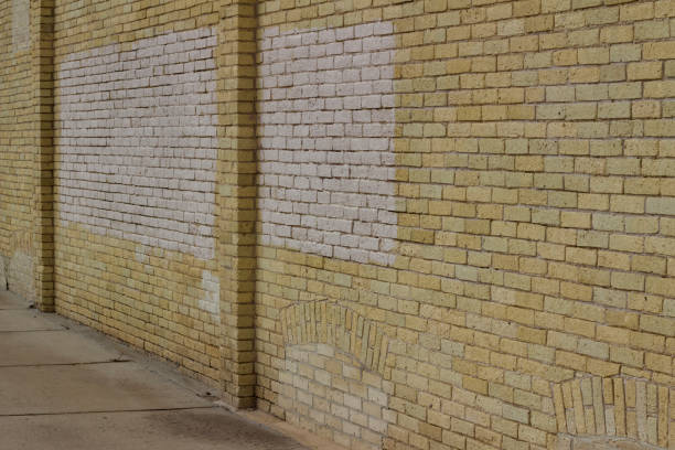 istock Charming old yellow brick wall background with shabby chic weathered texture (angle view) 1216500629