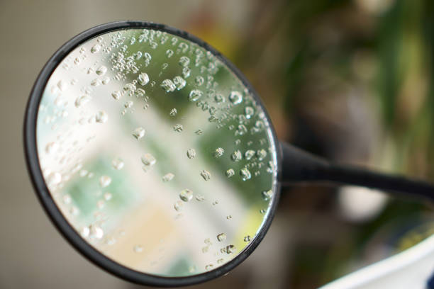 Raindrops on the motorbike's side circle glass mirror stock photo