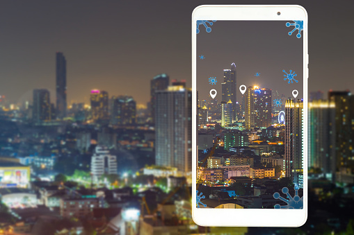 Night cityscape picture with a white mobile frame with virus icon notification point, colonavirus and technology concept.