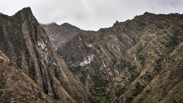 green meadow with distant mountains, cloudy sky background, location, san jeronimo, cusco, peru.