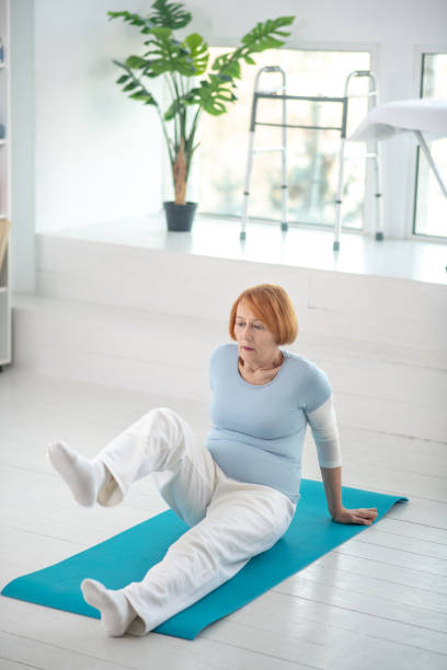 istock Nice active aged woman raising her leg 1216516923