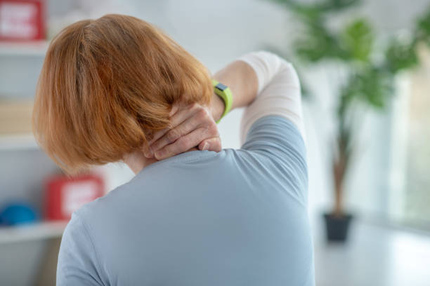 istock Red haired aged woman touching her neck 1216517027