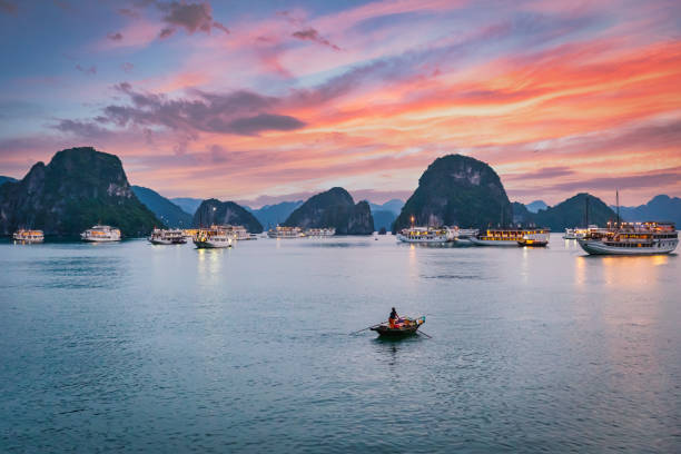 Halong Bay Sunset Colorful Twilight Vietnam Colorful Sunset Twilight over Halong Bay, UNESCO world heritage site and travel destination, popular for its fantastic limestone karsts and isles. Tourboats and Passenger Ships anchored in front of the Karst Limestone Islets.  Halong Bay, Quang Ninh Province, Northern Vietnam, Vietnam, Southeast Asia haiphong province photos stock pictures, royalty-free photos & images