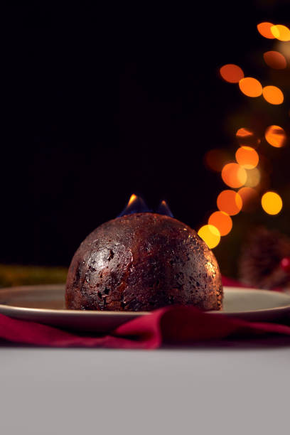 istock Brandy Soaked Christmas Pudding With Flames On Table Set For Festive Christmas Meal 1216523892