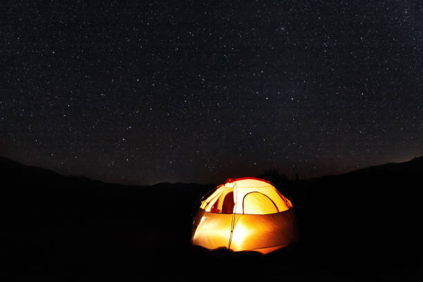 istock Illuminated camping tent under a sea of stars 1216524688