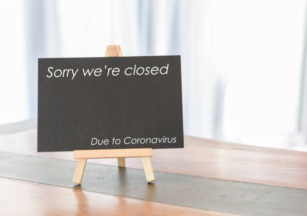 istock Blank black board on wooden desk in white room with closed text 1216525176