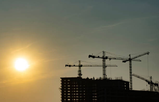 istock Silhouette of home construction, cranes, builders 1216526184