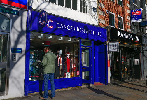 Cancer Research UK in Islington, London, with a person looking inside