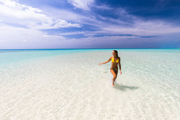 istock Young happy woman having fun while running through sea. 1216528562