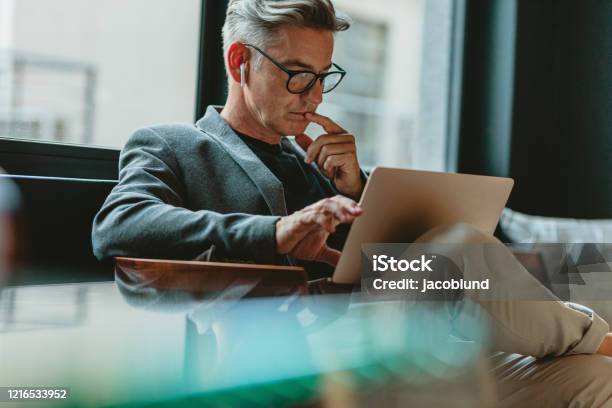Businessman Reading Emails In Office Lobby Stock Photo - Download Image Now - Business, Businessman, Men