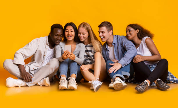 istock Cheerful classmates having break, watching videos on smartphone 1216534611