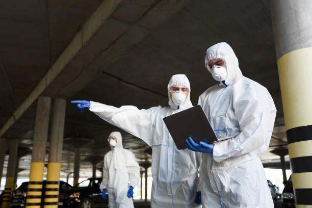 мужчины в специальных вирусных защитных костюмах, исследуя наличие коронавируса - protective suit фотографии стоковые фото и изображения