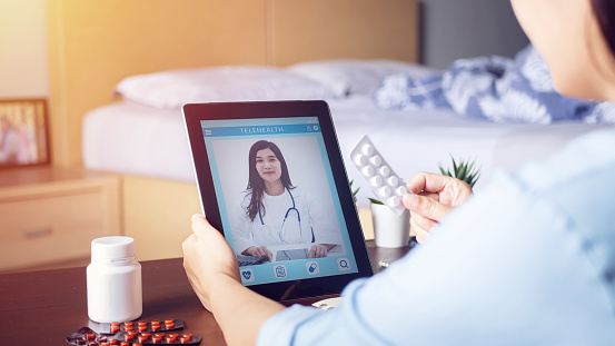 sick woman use video conference, make online consultation with doctor on digital tablet, patient ask doctor about illness and medication via video call. Telehealth, Telemedicine and online hospital