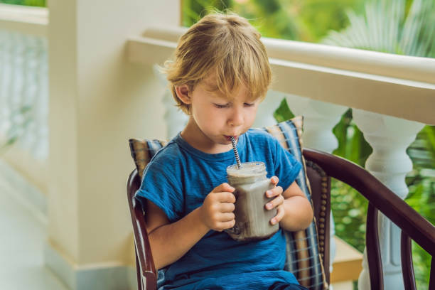 en pojke dricker en drink från en johannesbröd - yoghurt chocolate bowl bildbanksfoton och bilder