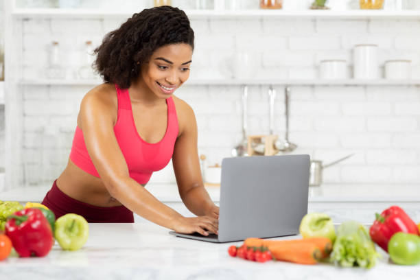 Black girl using laptop searching new recipes