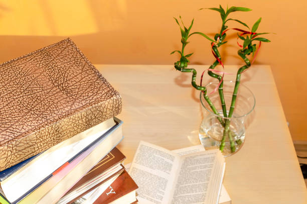 old books piled up on a table - old book stack open imagens e fotografias de stock