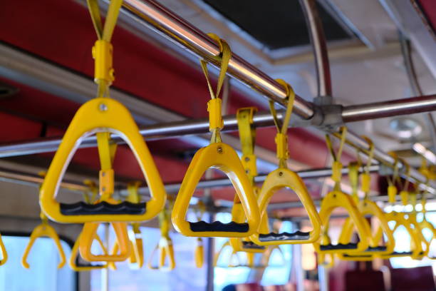 istock Yellow plastic handles on a metal handrail on the bus. 1216544436