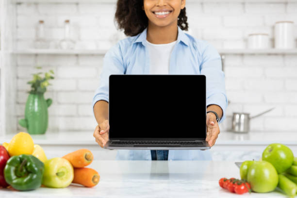 istock Unrecognizable black girl holding laptop in the kitchen 1216546497