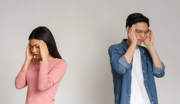 istock Asian couple having headache, touching their heads 1216546848