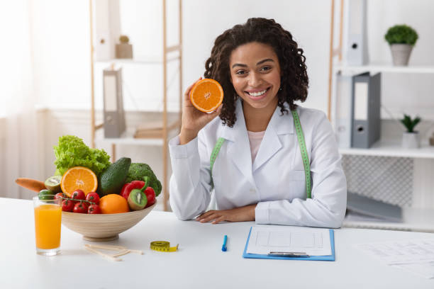 istock Modern dietologist african woman recommending fresh oranges 1216547058