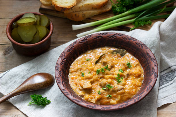 istock Bean and meat stew, served with pickles, bread and garlic. Rustic style. 1216550899