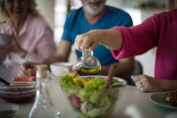 Enjoy a healthy meal. Group of people having lunch at home. Focus on hand.