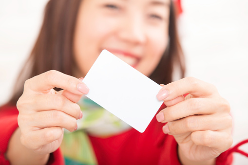 Asian Women enjoying shopping with credit card. Young smiling beautiful woman presenting credit card in hand for making payment shopping.
